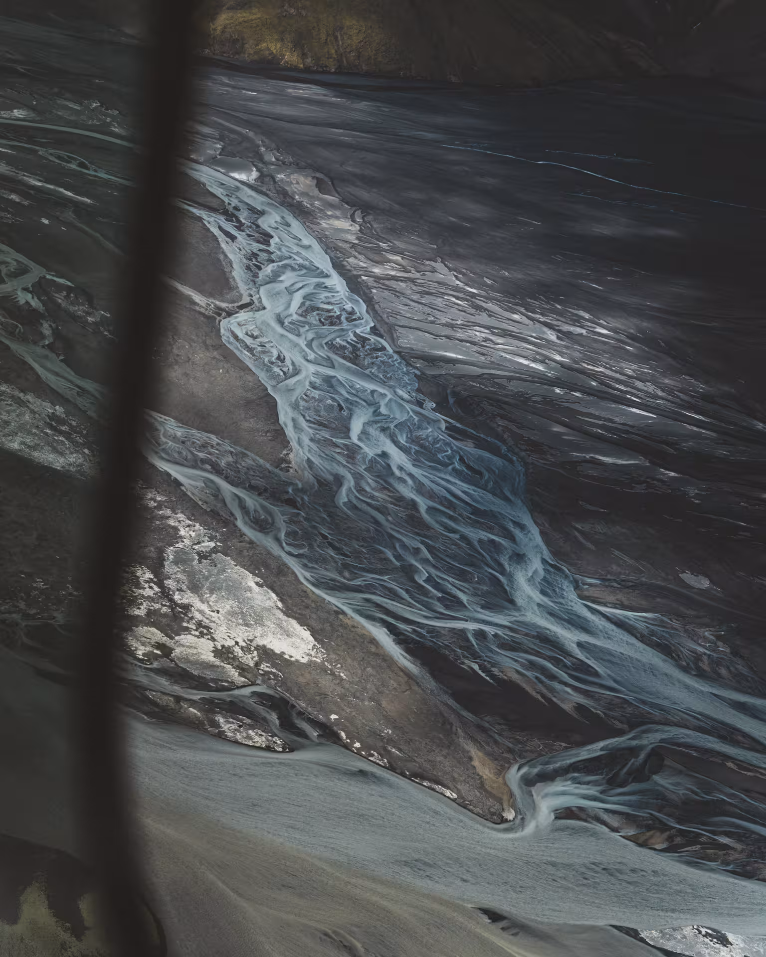 Aerial view of glacial braided river channels on Iceland's dark volcanic highland plains
