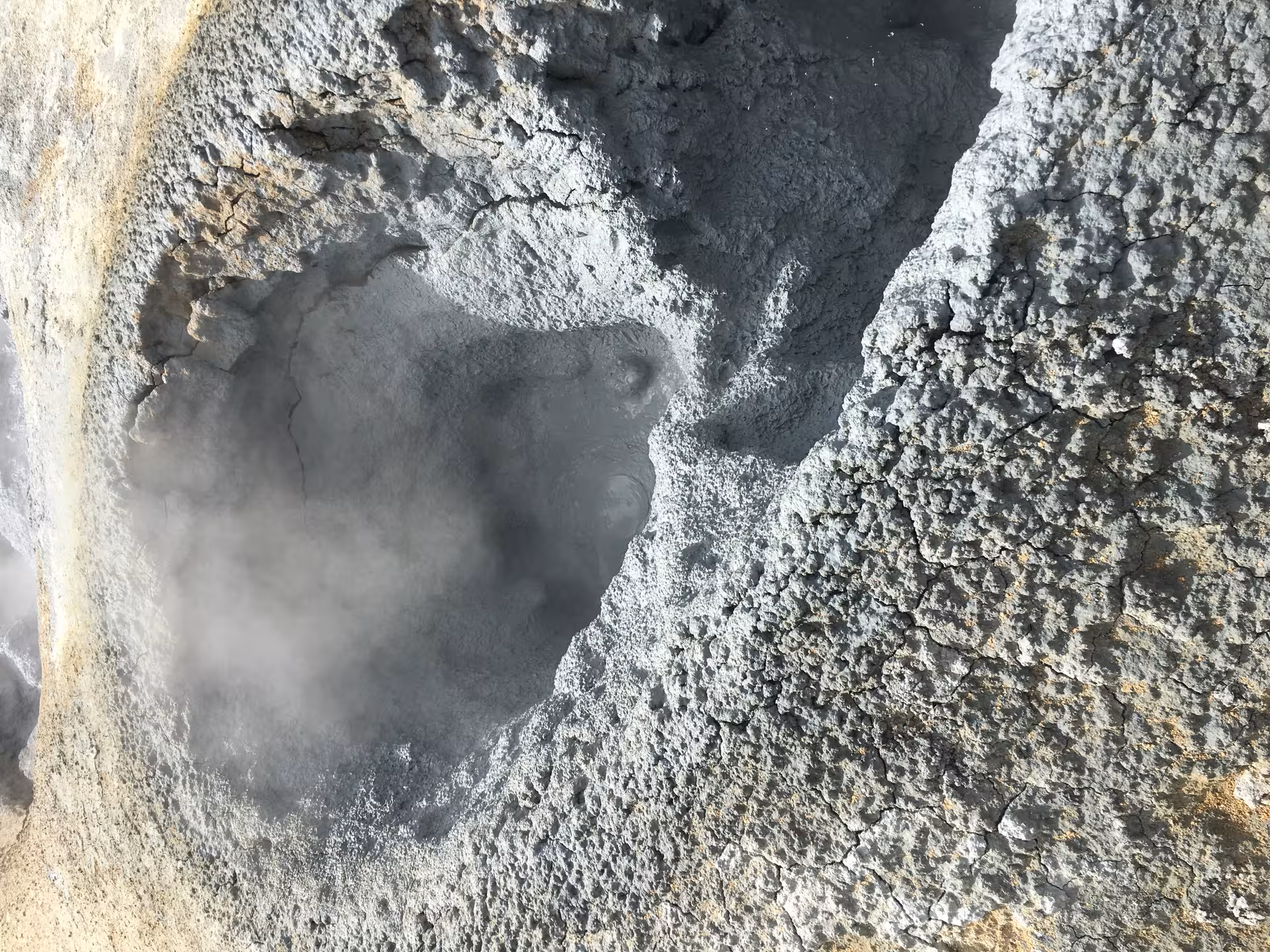 A steaming, textured mud pot in the geothermal area near Lake Myvatn highlights Iceland's volcanic features.