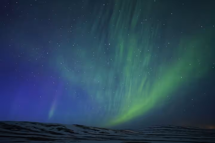 Aurora borealis northern lights dancing over snowy Iceland landscape at night