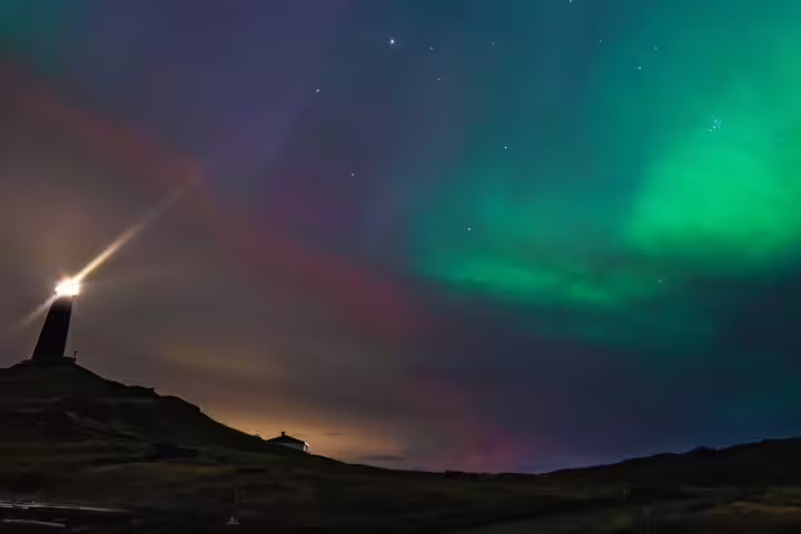Northern lights aurora borealis over a lighthouse in Iceland at night