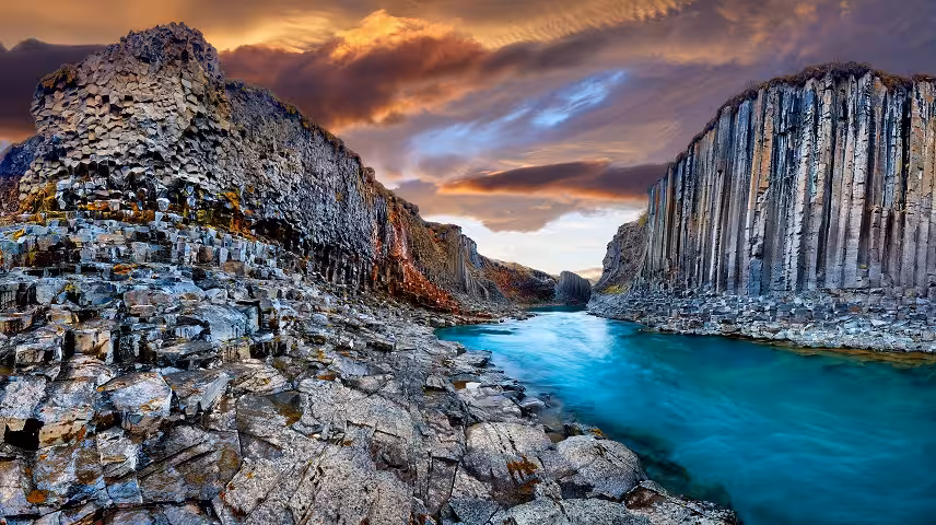 Stuðlagil basalt column canyon with turquoise river in Iceland at dramatic sunset