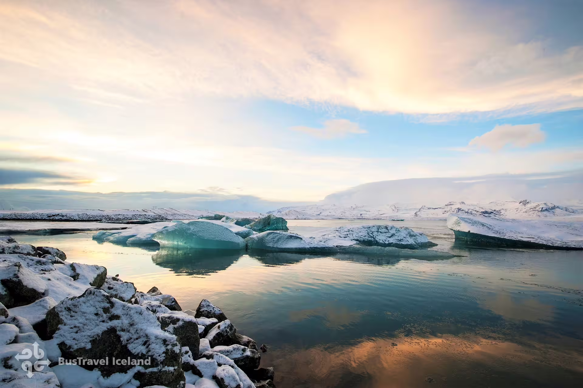 Turquoise icebergs floating on Jökulsárlón glacial lagoon in Iceland during golden hour winter sunset