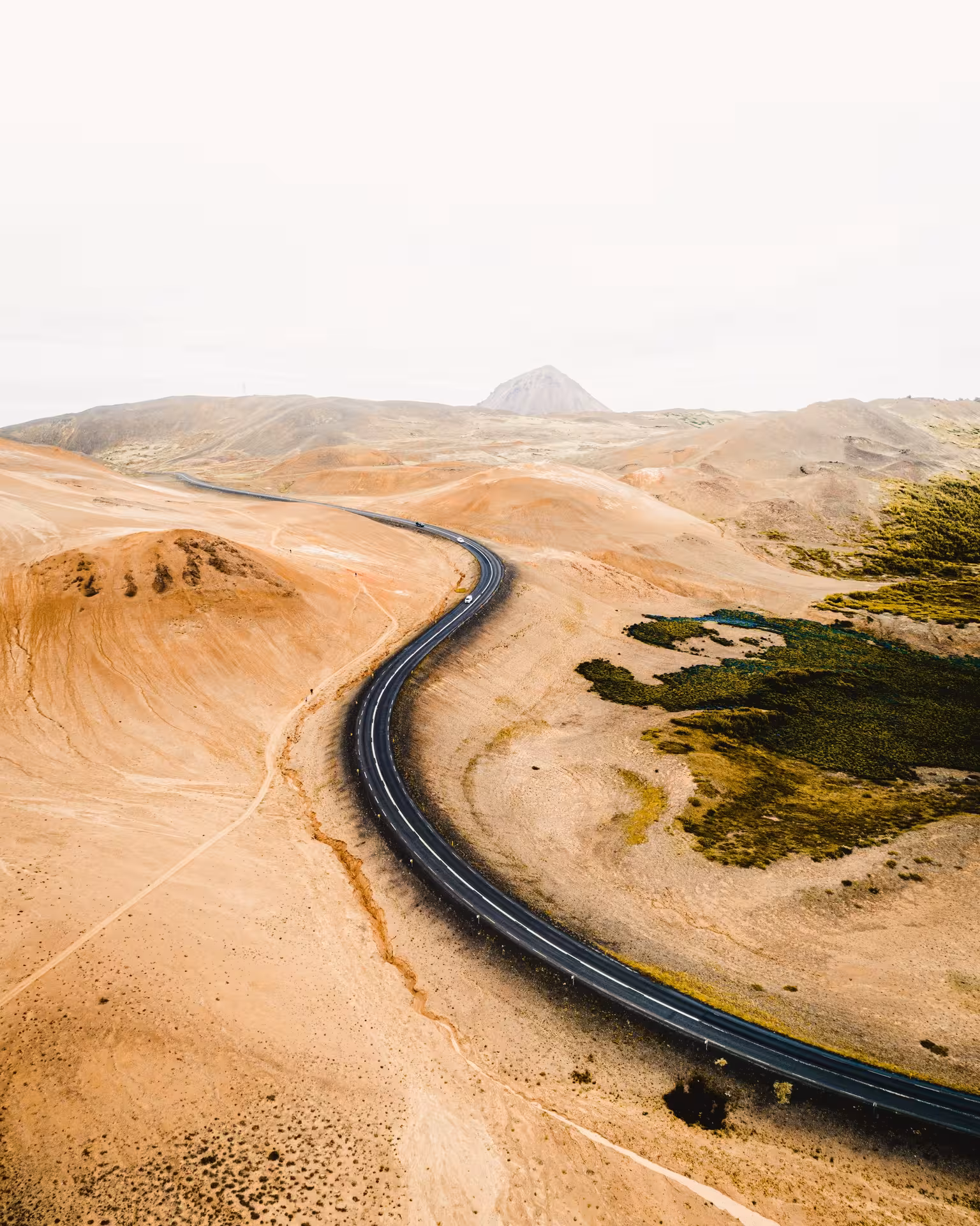 Scenic Icelandic road winding through barren landscapes, perfect for a 10-day self-drive adventure journey.