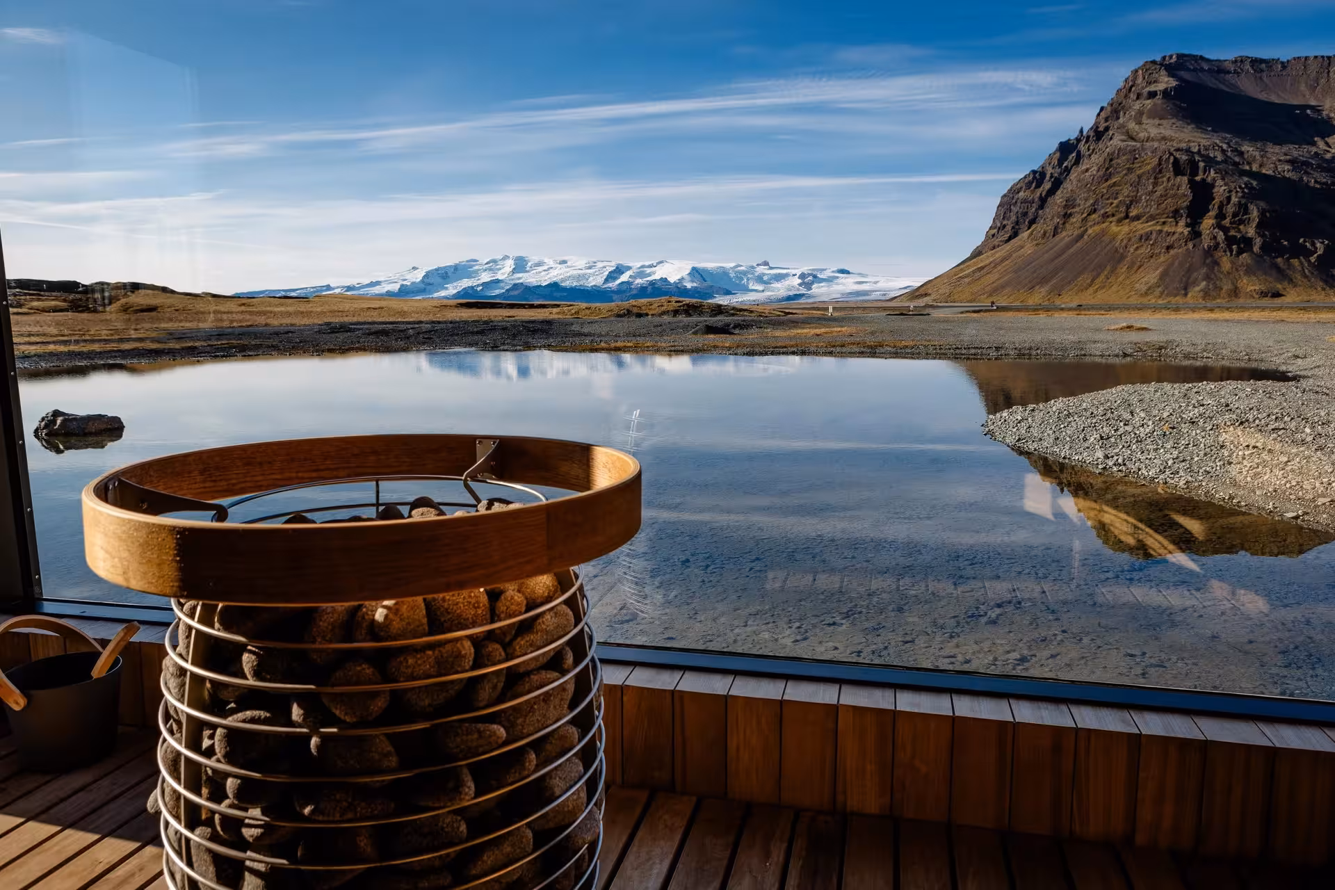 Iceland sauna interior with stunning glacier lagoon and snow-capped mountain views on a sunrise proposal tour