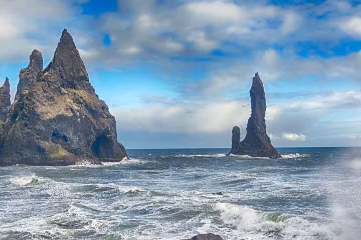 Dramatic black basalt sea stacks rising from rough Atlantic waves on Iceland's South Coast