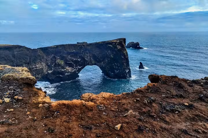 Black volcanic rock arch over the ocean on Iceland's dramatic south coast
