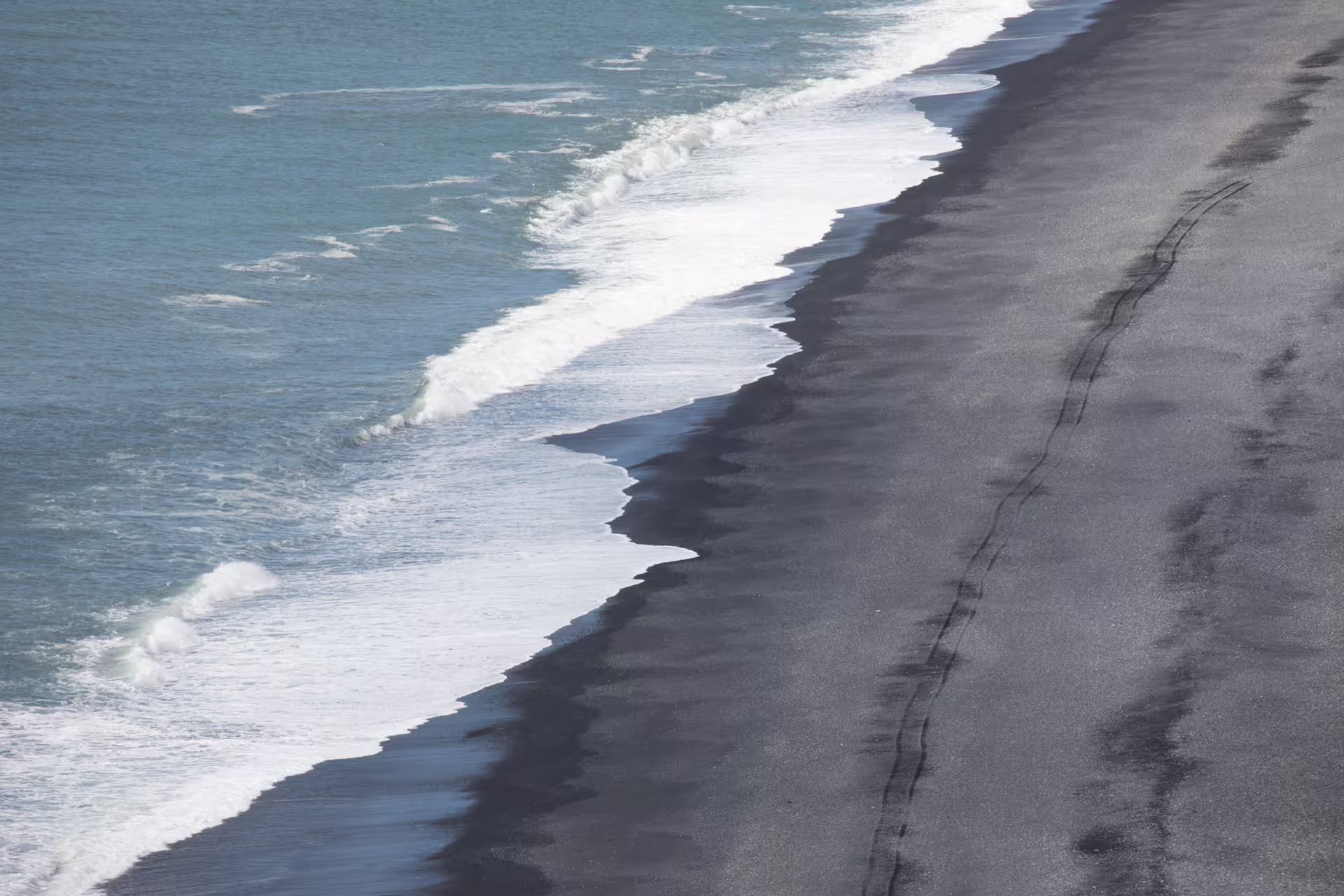 Black volcanic sand beach with white waves on Iceland's South Coast