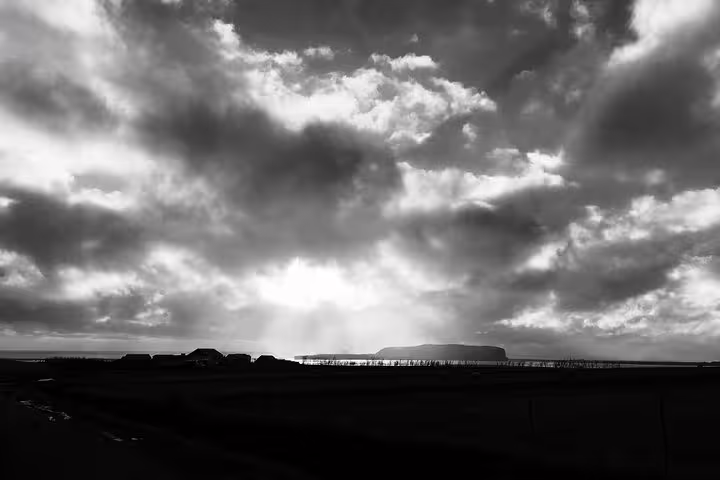 Dramatic black and white sky over Iceland south coast landscape with flat mesa silhouette