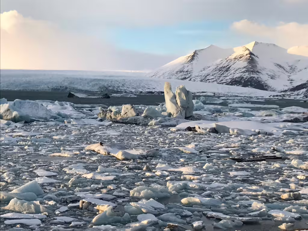 Jökulsárlón glacier lagoon with floating ice chunks and snow-capped mountains on Iceland's south coast