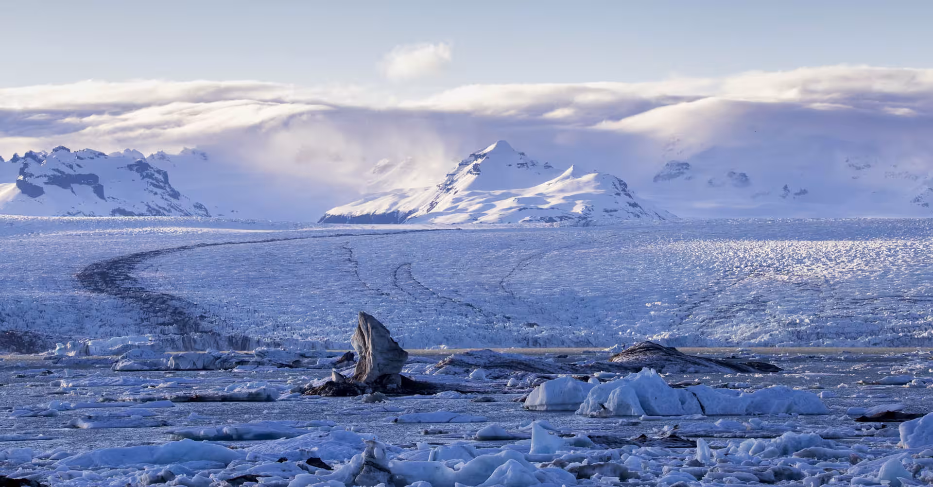 Jökulsárlón Glacier Lagoon with floating icebergs, vast glacier, and snow-capped mountains in Iceland's south coast