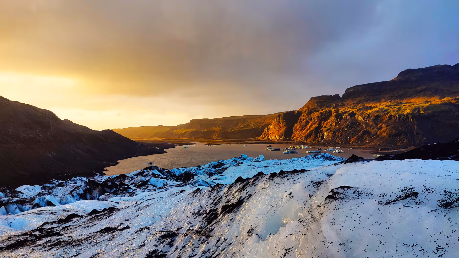 Glacier and glacial lagoon with icebergs at golden sunset on Iceland's south coast