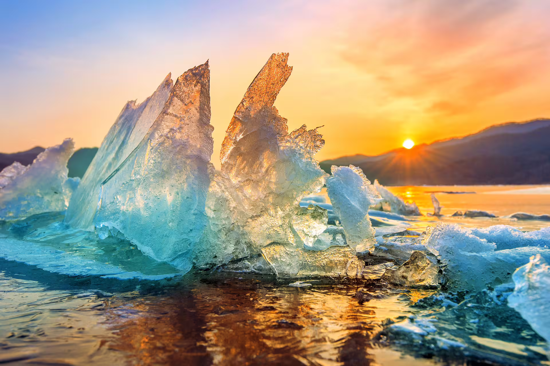 Jagged ice formations glowing in golden sunset light on Iceland's frozen south coast landscape