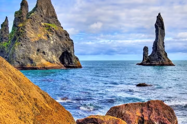 Dramatic basalt sea stacks rising from turquoise ocean waters along Iceland's South Coast
