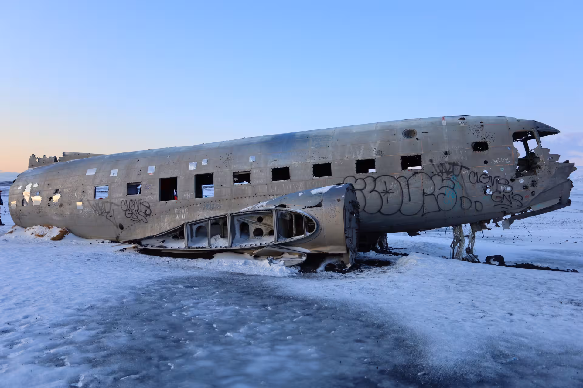 Abandoned DC-3 plane wreck covered in graffiti on Iceland's snow-covered Sólheimasandur black sand beach