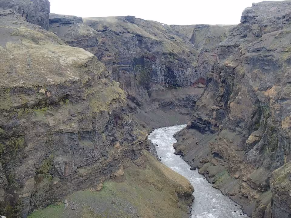Deep rocky canyon with rushing river winding through steep volcanic cliffs in Iceland's highlands