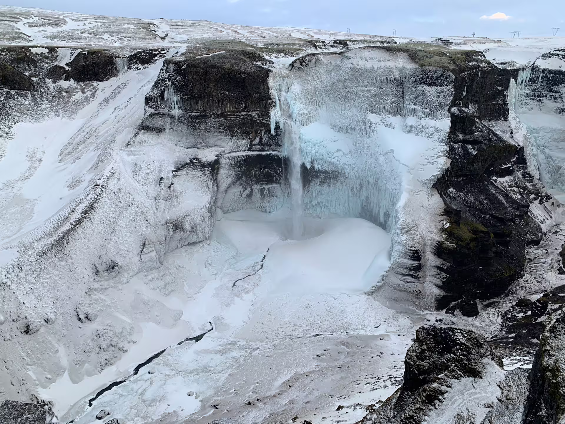 Frozen waterfall in an icy canyon during a winter Super Jeep tour in Iceland