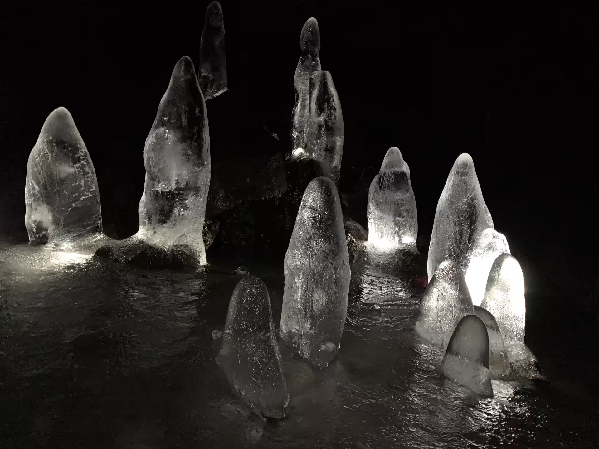 Illuminated ice stalagmites glowing at night during Iceland Super Jeep tour
