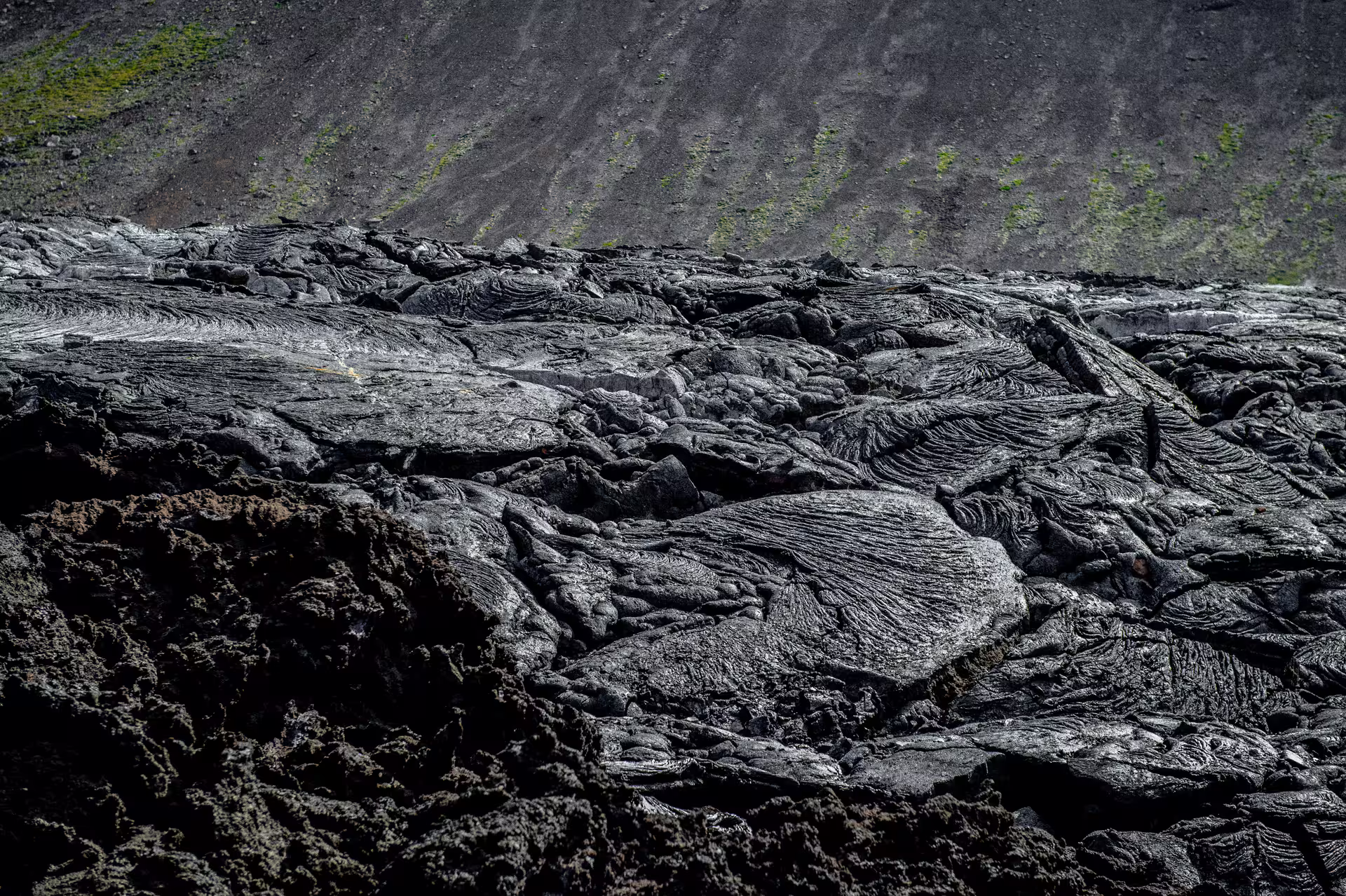 Hardened black pahoehoe lava field with rope-like textures on an Iceland volcano hike