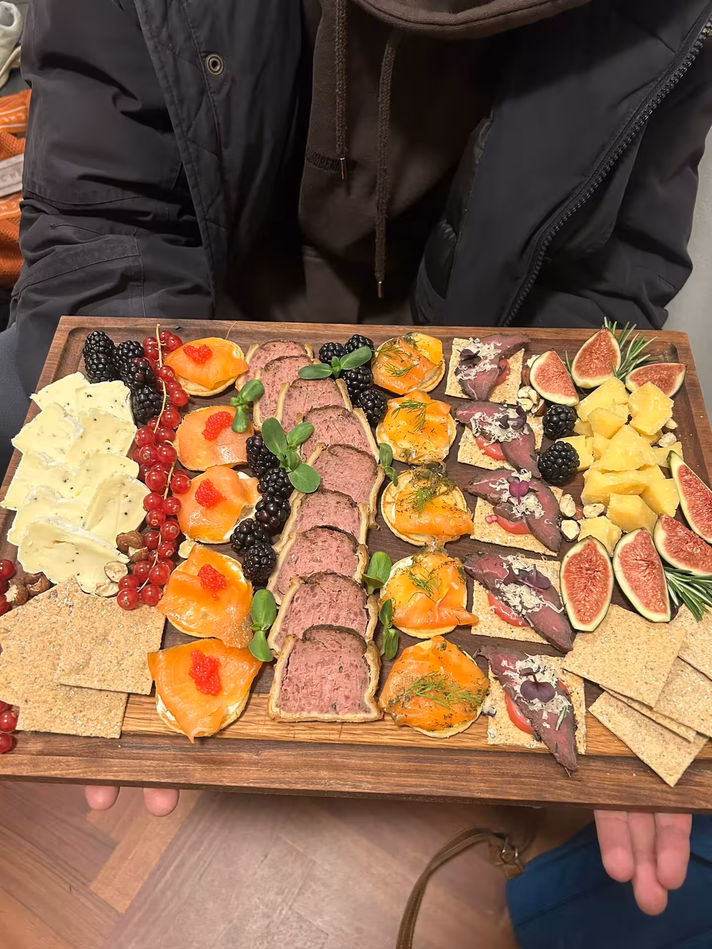 Exquisite Icelandic charcuterie board with smoked salmon, cured meats, fresh figs, and berries on a Northern Lights luxury cruise