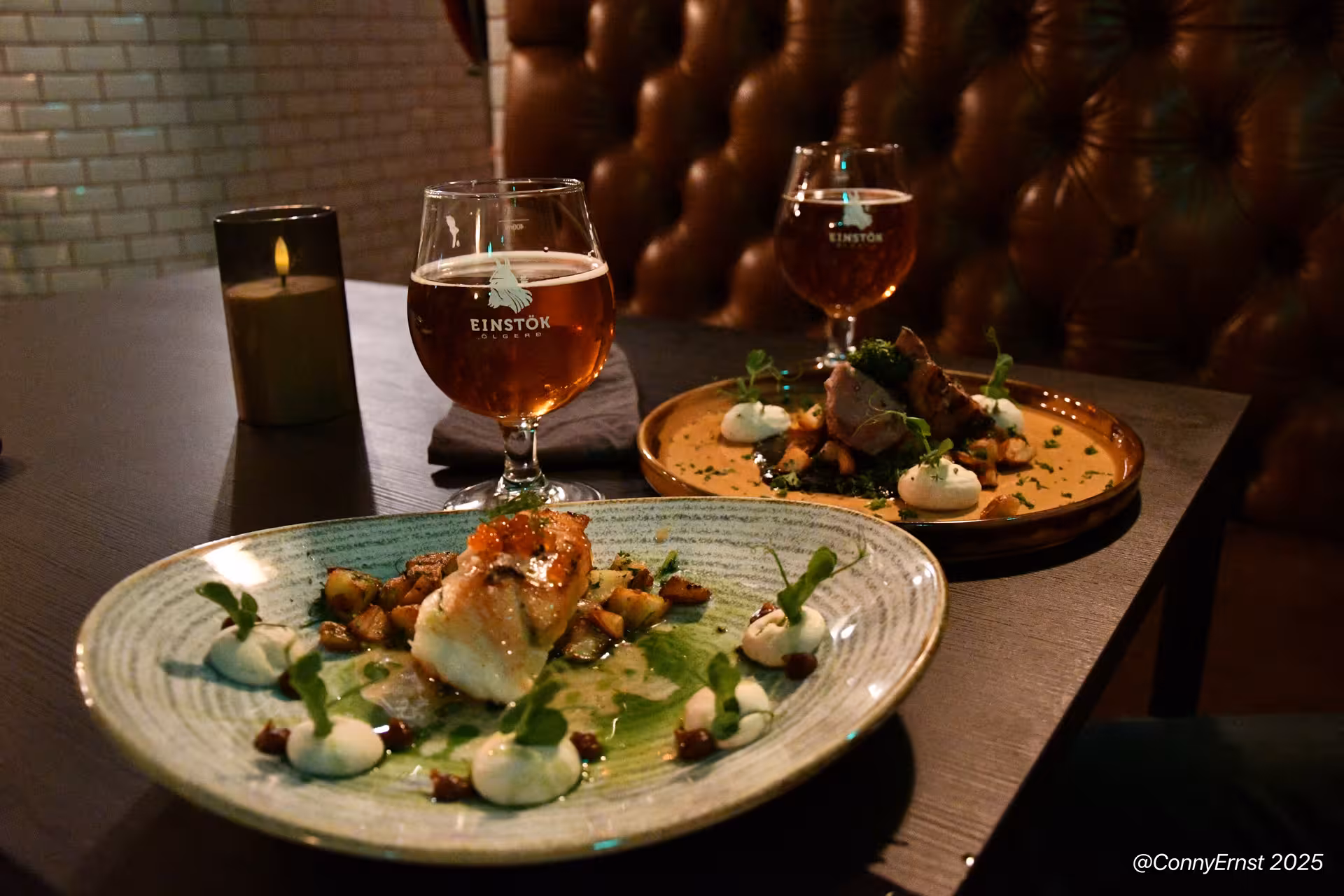 Two plated Icelandic dishes with fish and meat served with Einstök beer glasses at a Reykjavik restaurant