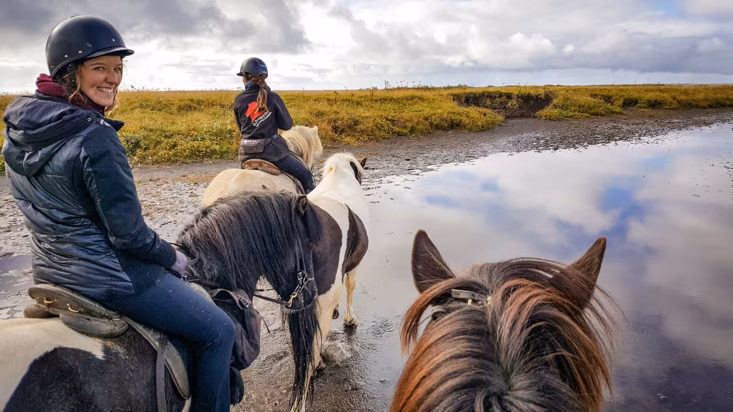 Riders crossing shallow lagoon on Icelandic horses, 05B Below the Mountains tour through scenic lowlands