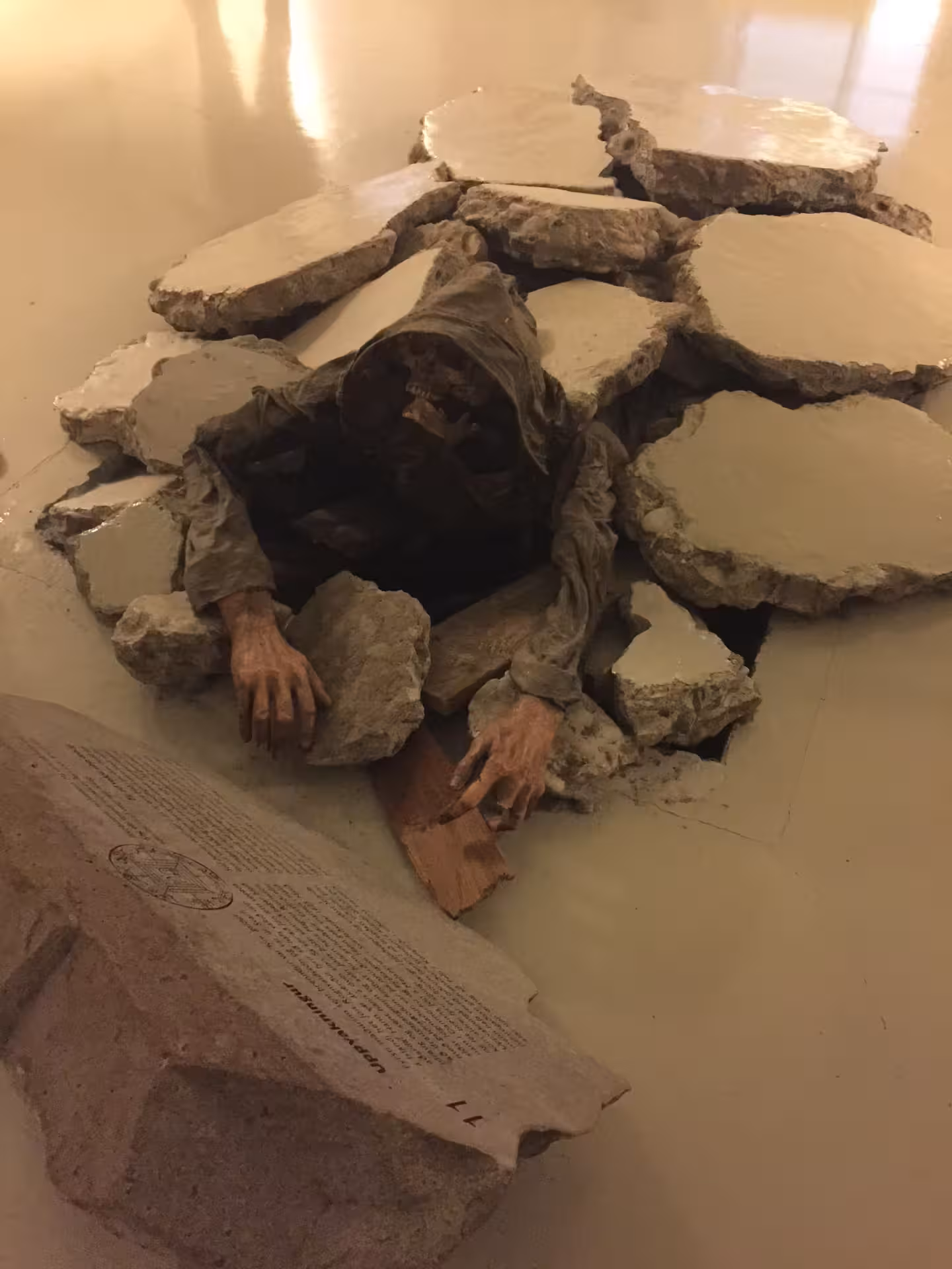 Eerie Icelandic magic museum exhibit showing a skeletal figure emerging from a broken wall linked to dark sorcery lore