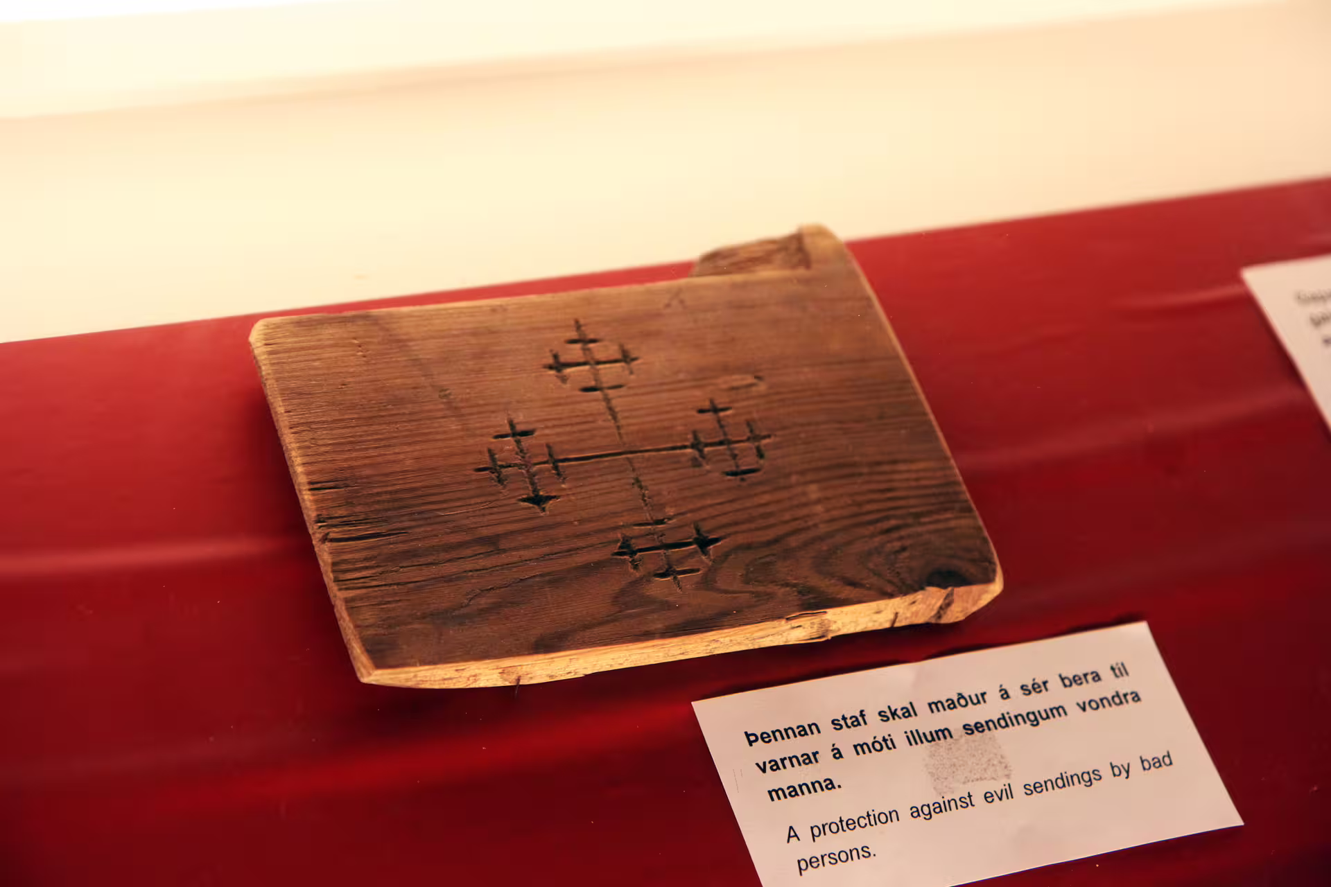 Wooden artifact carved with Icelandic protection stave displayed in a witchcraft museum exhibit in Iceland
