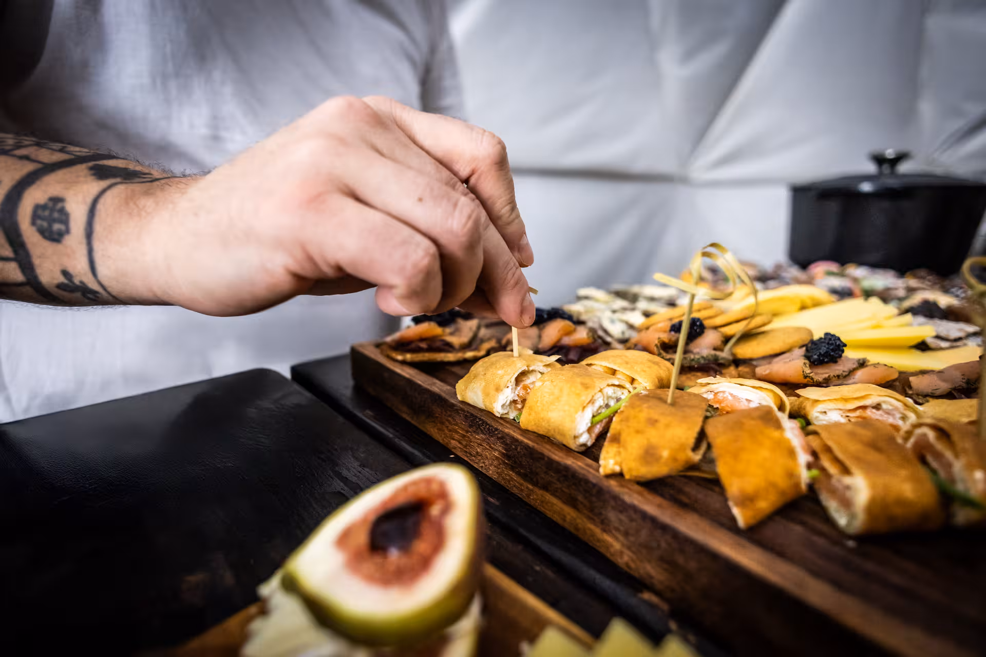 Chef carefully garnishing a gourmet Icelandic appetizer platter with smoked salmon crepes and caviar for a northern lights dining experience