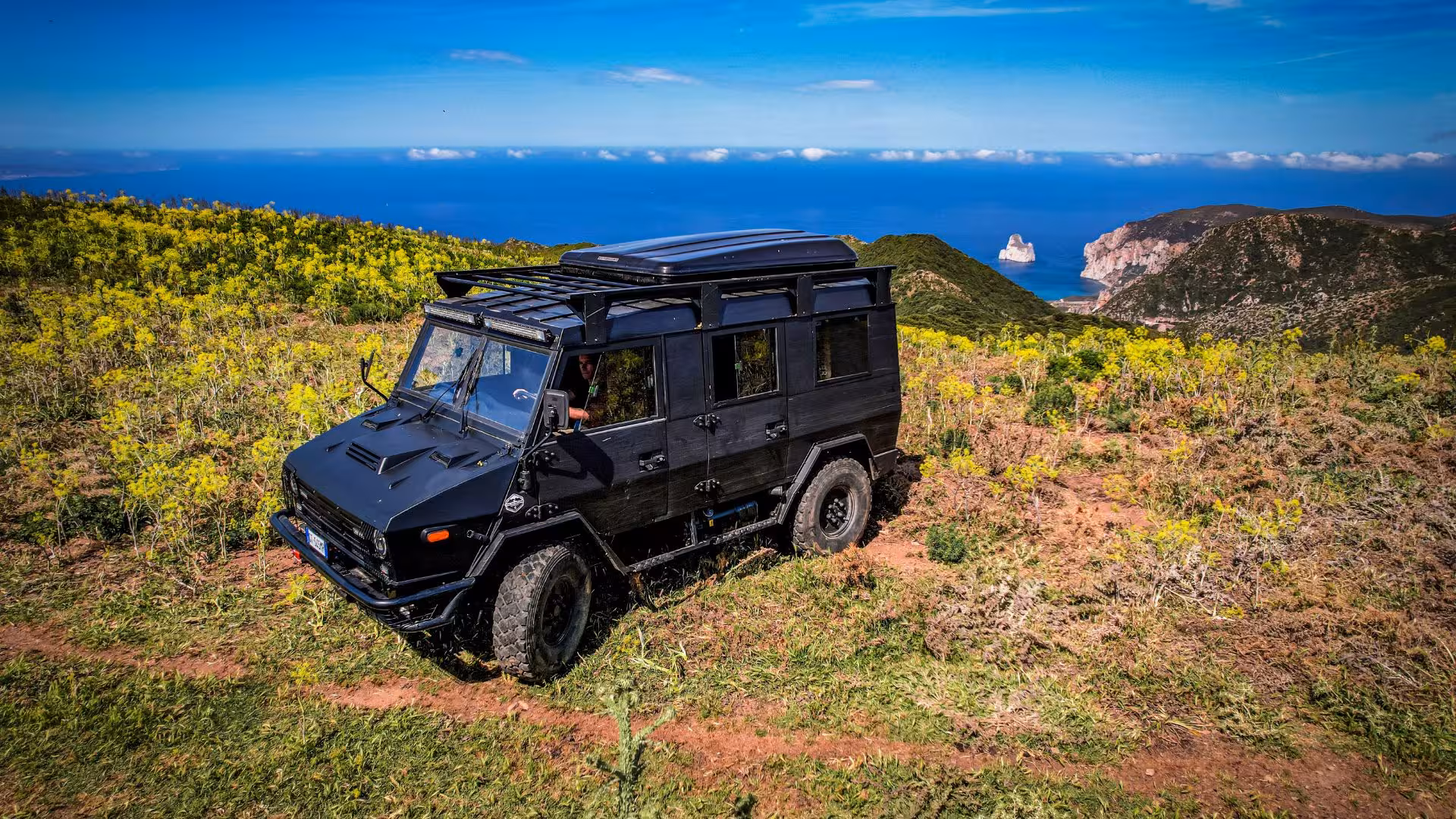 Off-road jeep on a picturesque hillside with sea views, part of the Iglesias adventure tour experience.