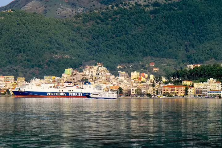 Igoumenitsa port waterfront with ferry and hillside town, ideal start for private transfer from Igoumenitsa to Athens