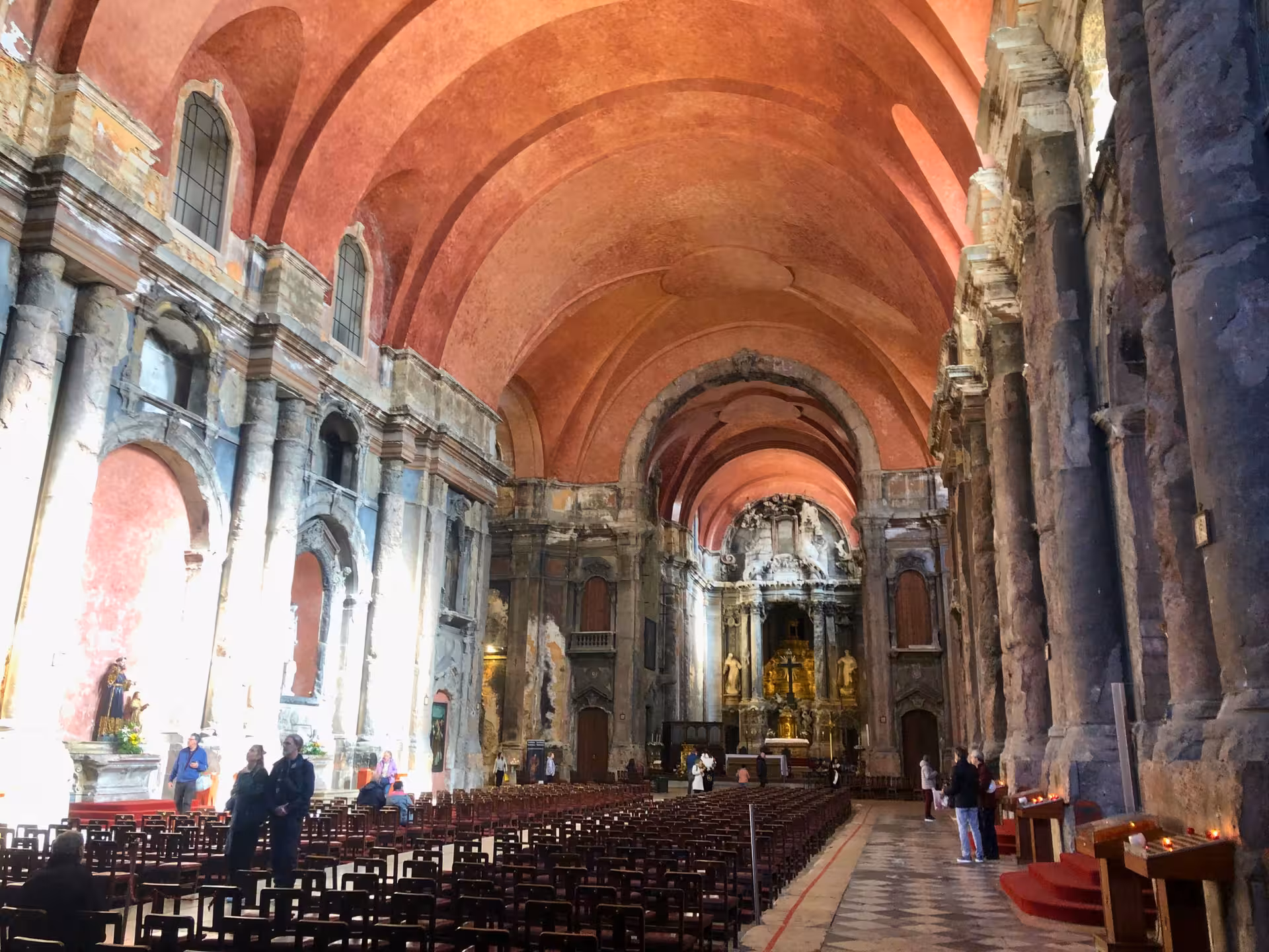 Interior of Igreja de São Domingos in Lisbon with vaulted red ceiling, historic nave and altar