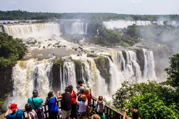 Tourists enjoying the breathtaking view of Iguazu Falls on a sunny day during the Argentine and Brazil full-day tour.