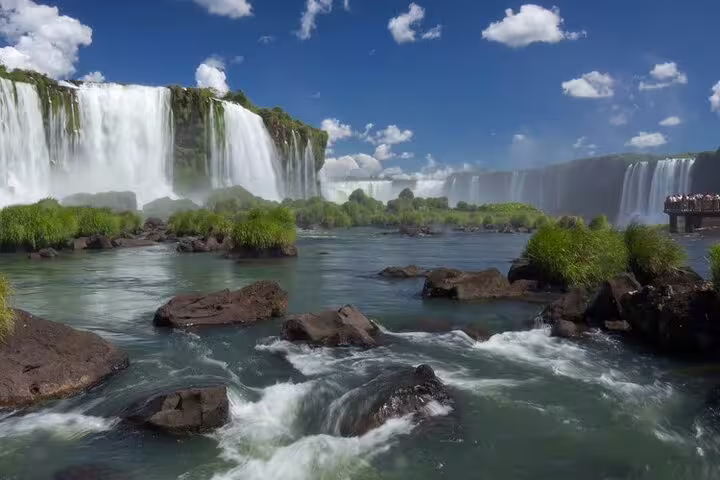 Scenic view of Iguazu Falls with lush greenery and foamy water, perfect for a thrilling guided tour experience.