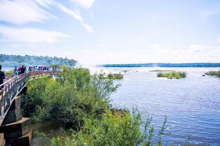 Visitors enjoy panoramic views of Iguazu Falls from a scenic walkway on the Argentine side during a private tour.