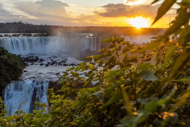 Stunning sunset over Iguazu Falls with lush greenery, ideal for a 4-day guided tour experience.