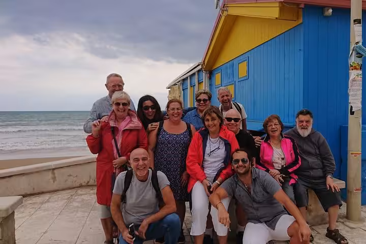 Group of tourists enjoying a visit to the vibrant coastal town of Punta Secca, featured in Il Commissario Montalbano.