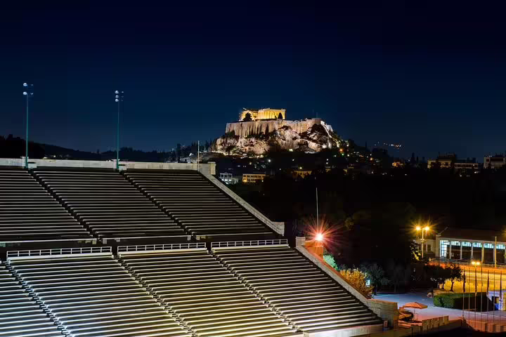 Illuminated Acropolis at night seen from Panathenaic Stadium on a private Athens city tour with skip-the-line