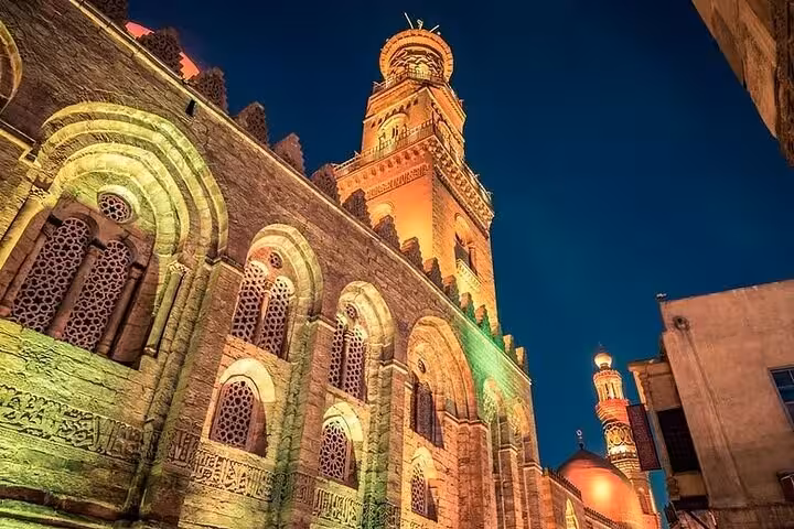 Illuminated historic mosque on Al Muizz Street in Islamic Cairo during a VIP Cairo night tour after dark