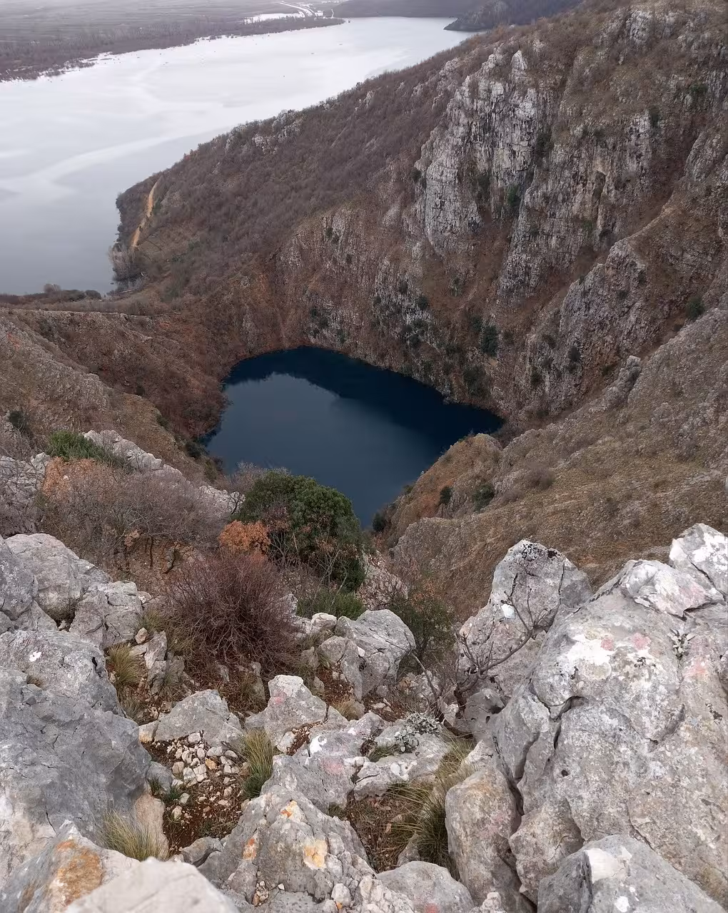 Dramatic overlook of Imotski Red Lake sinkhole and cliffs, a must-see stop on a Split hidden gems tour