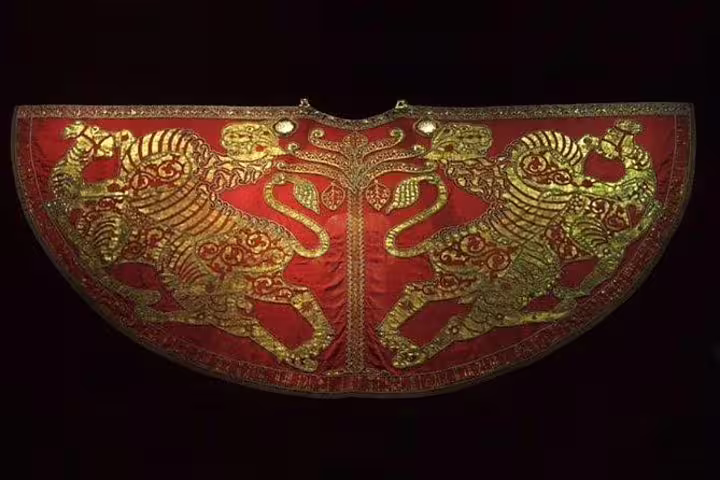 Intricately embroidered imperial cloak with golden motifs, a highlight of the Kaiserliche Schatzkammer's royal collection.