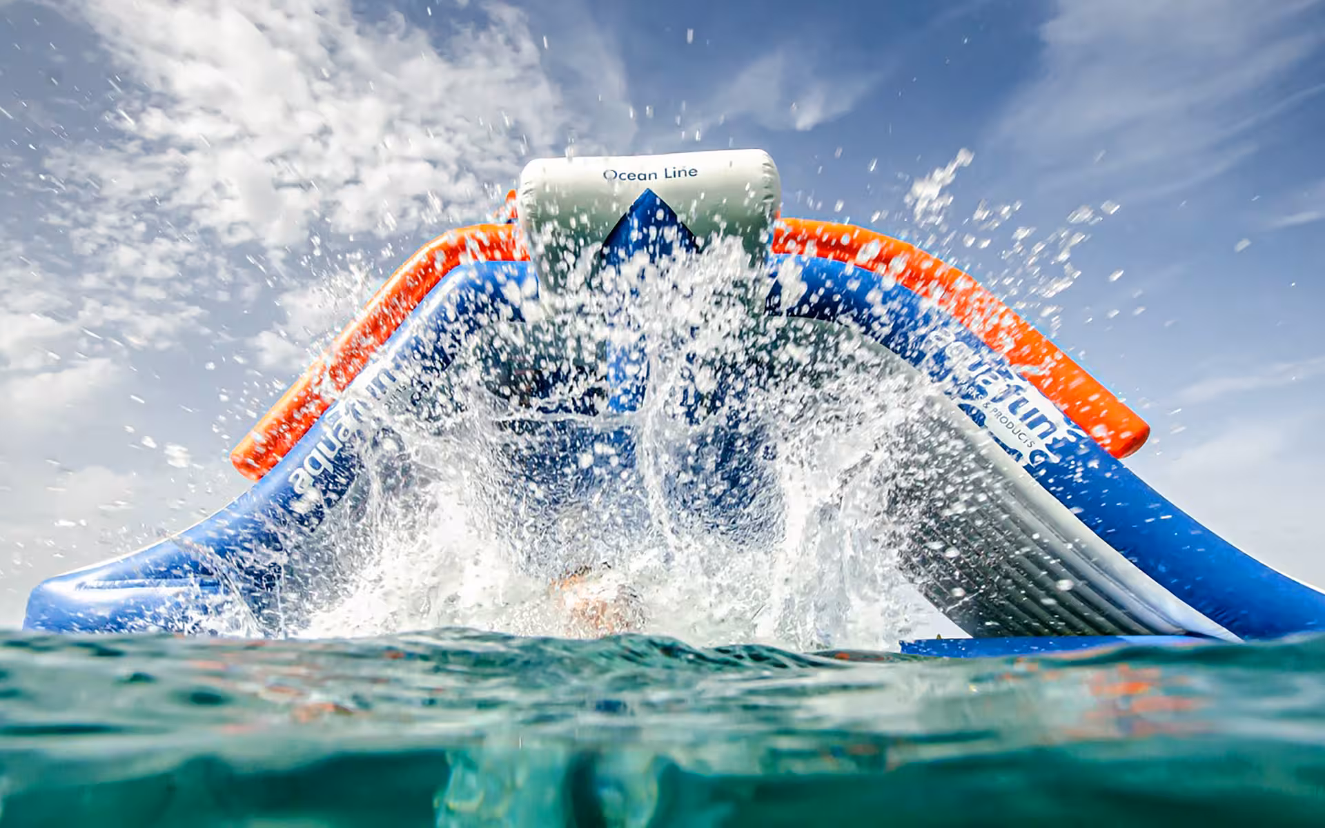 Thrilling water splash at the base of an inflatable slide at an exciting open-water inflatable waterpark