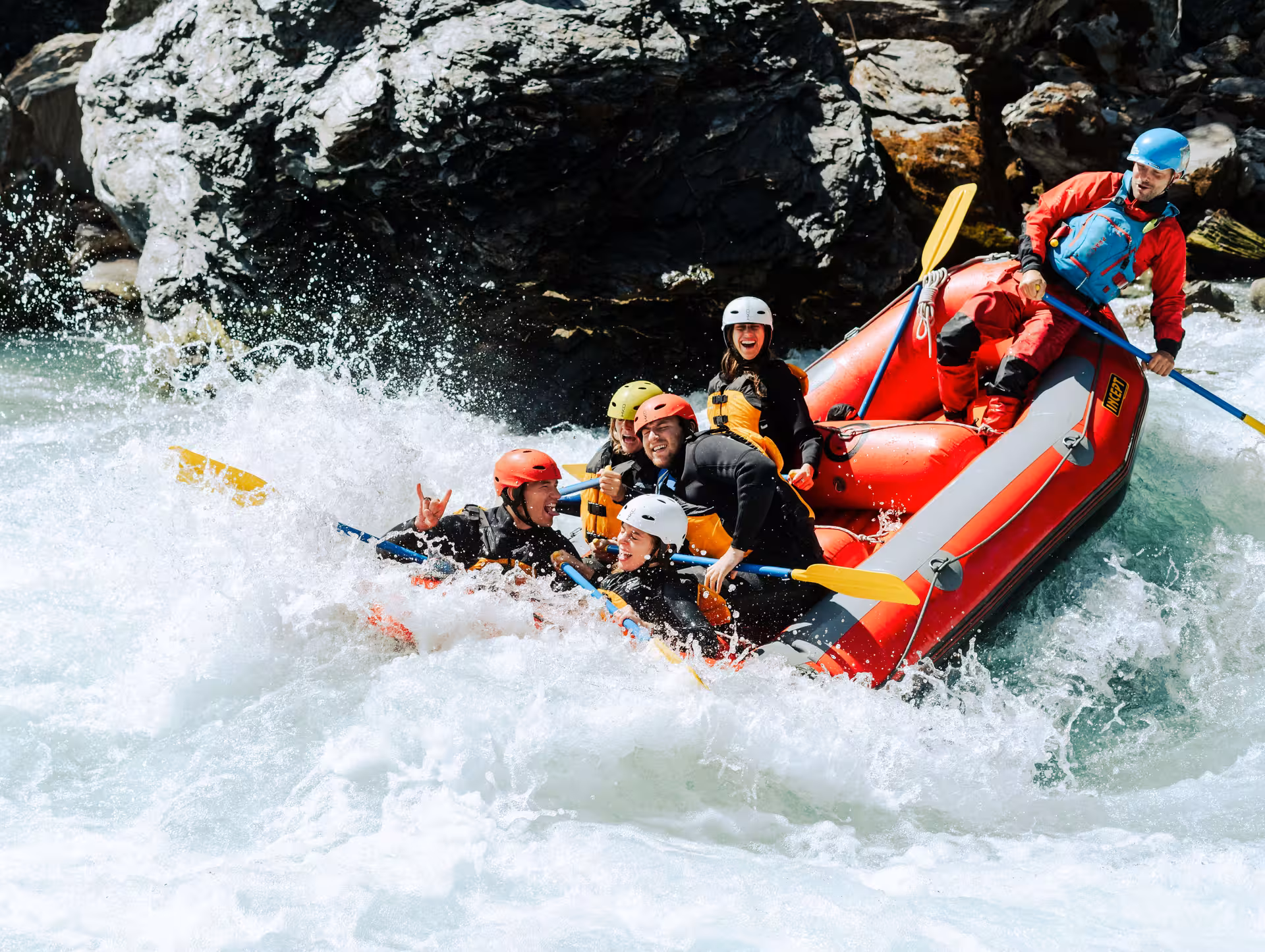 Energetic rafters tackle challenging waves in Interlaken, experiencing the excitement of a whitewater rafting journey.