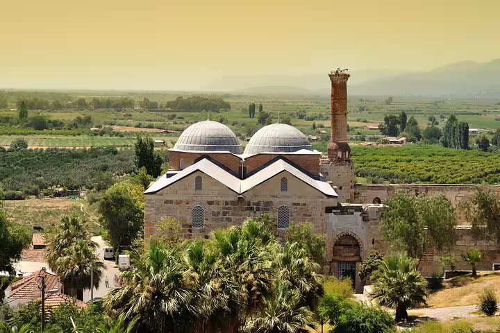 Scenic view of Isa Bey Mosque surrounded by lush greenery on an Ephesus day tour from Istanbul with flights.