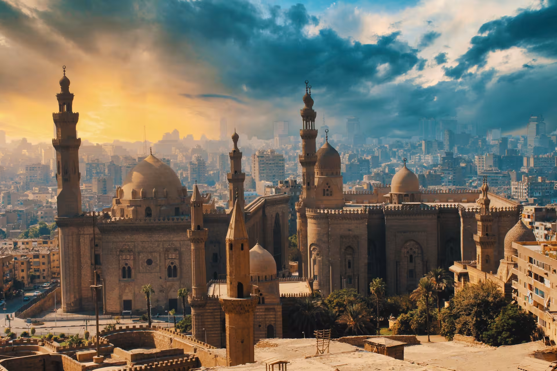 Aerial view of Sultan Hassan Mosque and Al-Rifa'i Mosque minarets and domes in Islamic Cairo at sunset