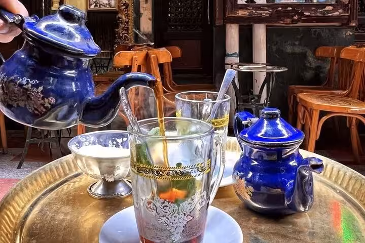 Mint tea poured from blue teapot at Cairo cafe, a street food stop on Islamic Cairo walking tour