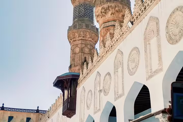 Ornate mosque courtyard with carved arches and minarets in Islamic Cairo on a historical mosques tour