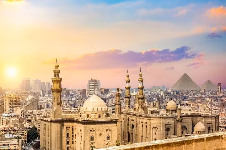 Sunset view over Islamic Cairo mosque domes and minarets, near NEMIC and Giza Pyramids skyline