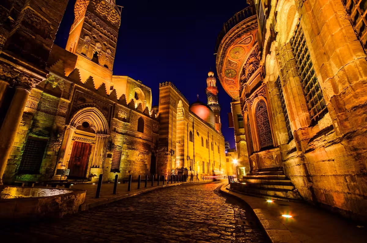 Night view of historic Islamic Cairo street with illuminated mosques, part of exclusive private Cairo tour
