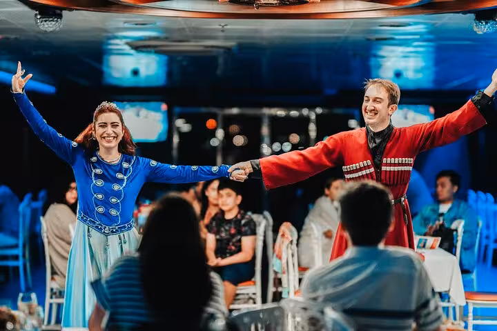 Turkish night folk dancers performing on Istanbul Bosphorus dinner cruise with live show and guests dining
