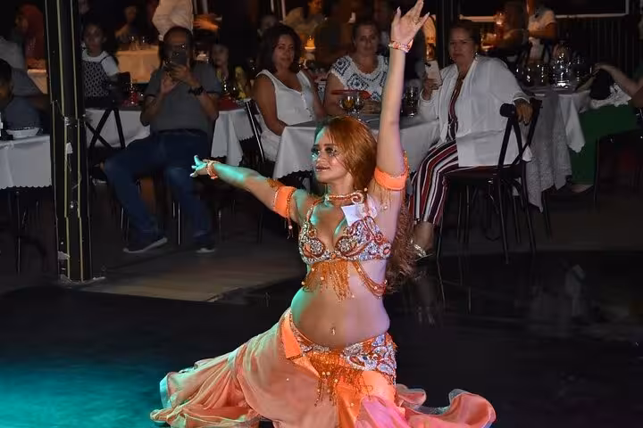 Belly dancer performs live on Istanbul Bosphorus New Year’s Eve dinner cruise party with guests dining